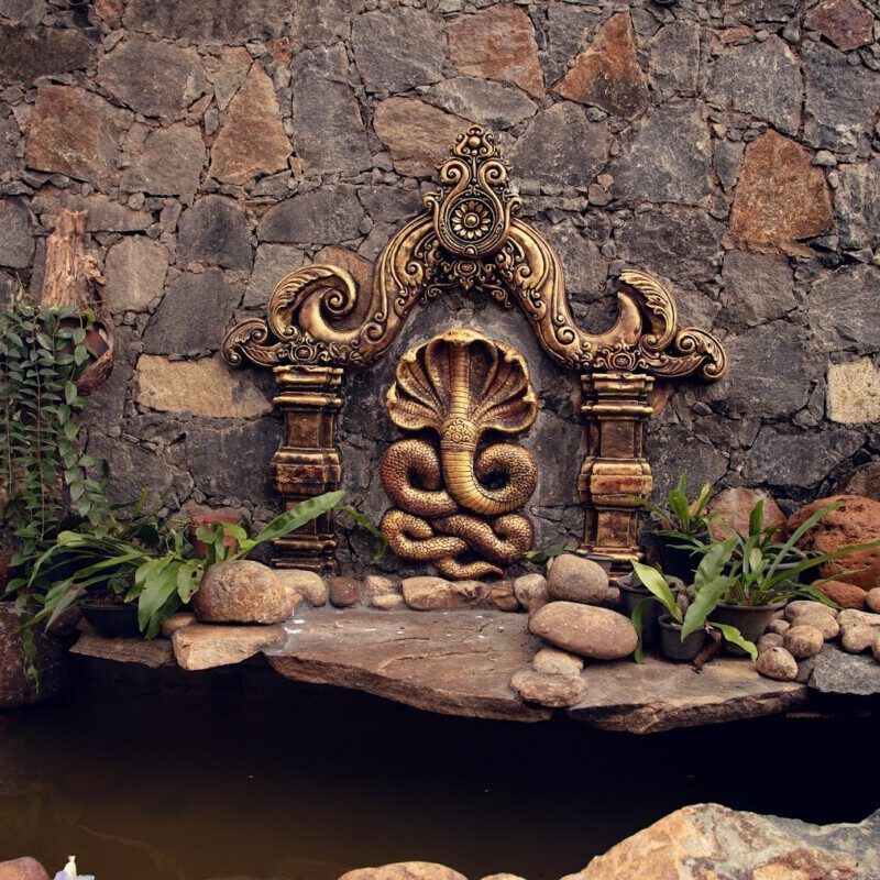 Gold-colored icon of naga at pond