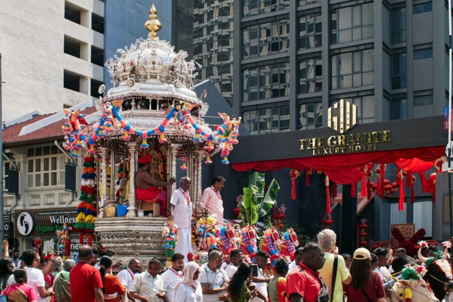A bustling Thaipusam procession winds through the streets of Malaysia, anchored by the ornate silver chariot carrying Murugan, the “icon of war.”
