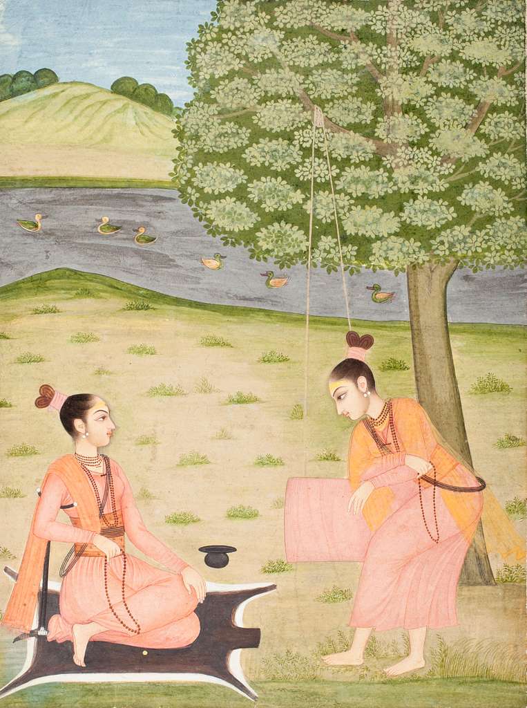 An 18th-century painting of two female ascetics in saffron robes by a river. One sits cross-legged on a black deerskin under a tree, while the other stands beside a rope swing. Ducks float on the river against gentle hills in the background.